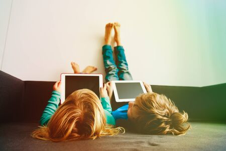 little boy and girl looking at touch pad at home