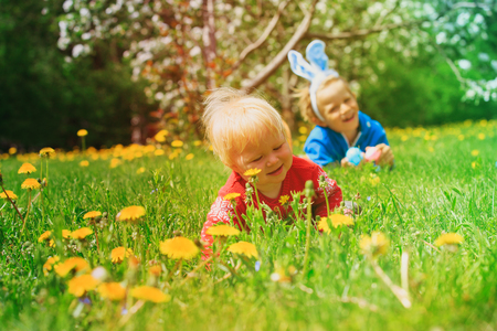 happy kids on easter eggs hunt in springの写真素材