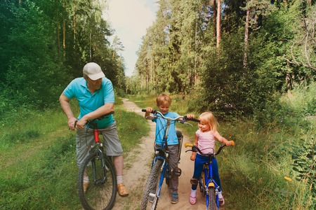 active senior with grandkids riding bikes in natureの写真素材