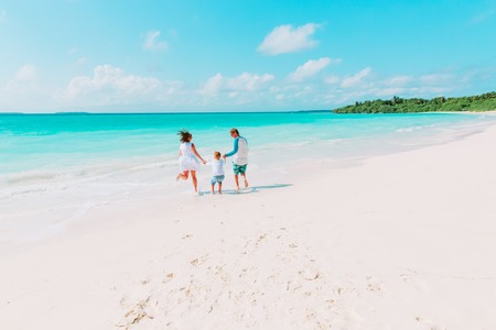 family with little child having fun on beachの写真素材