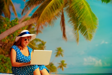remote work concept -young woman with laptop on beachの写真素材