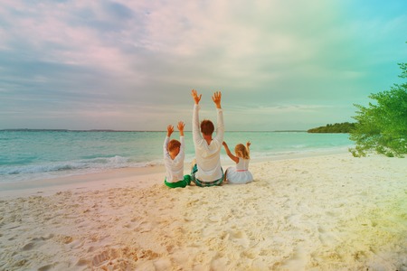 father with little son and daughter having fun on beachの写真素材
