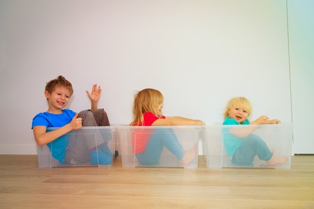 kids playing wtih boxes in new house
