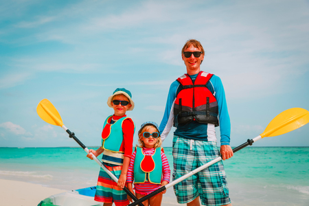 father with little son and daugther kayaking at beachの写真素材