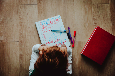 little boy tired stressed of doing homeworkの写真素材