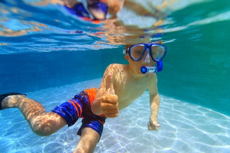happy little boy swim underwater with thumbs upの写真素材