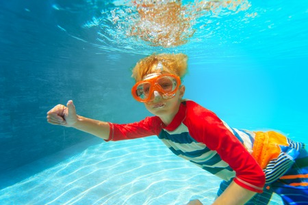 happy little boy swim underwater with thumbs upの写真素材