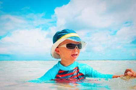 little boy having fun on tropical beachの写真素材