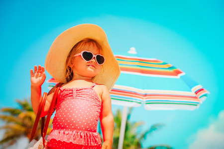 cute little girl with big bag on beachの写真素材