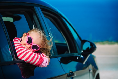 happy little girl enjoy travel by car at seaの写真素材