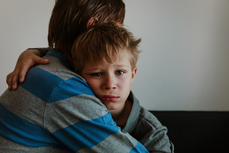 Father comforting sad child, parenting, sorrow