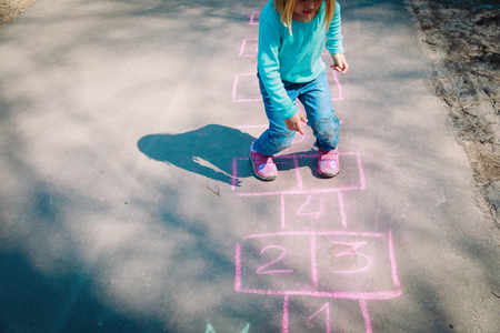 little girl play hopscotch on playgroundの写真素材