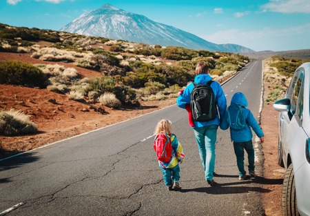 family travel by car-father with kids on road in mountainsの写真素材