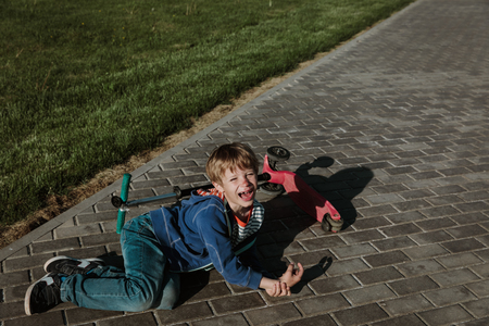 crying child fall off scooter, blood on his faceの写真素材