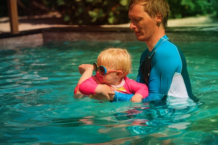 Father teaching little daughter to swimの写真素材