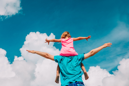 father and little daughter play at skyの写真素材