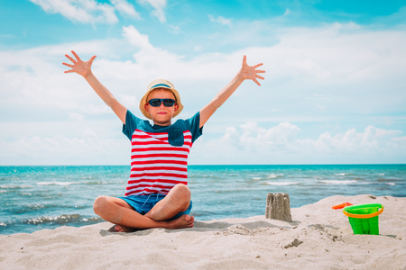 happy boy hands up enjoy tropical beachの写真素材