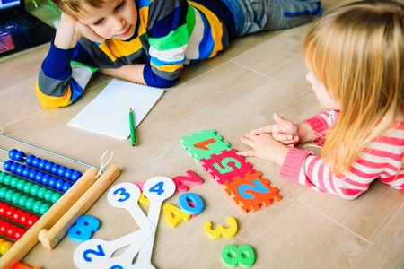 little boy and girl learn to write and calculate numbers
