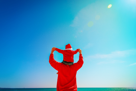 father and baby play at sky on Christmas beachの写真素材