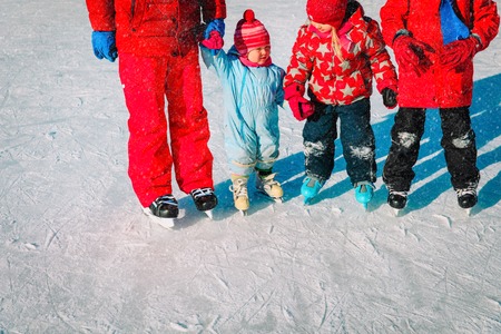 father with kids skating in winter natureの写真素材