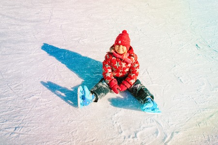 happy little girl learning to skate in winterの写真素材