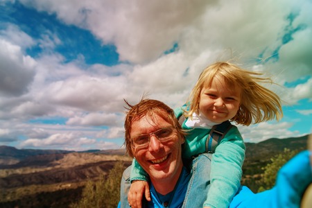 happy father with little daughter making selfie travel in nature