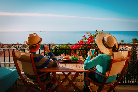 young couple have breakfast on balcony terrace with sea viewの写真素材