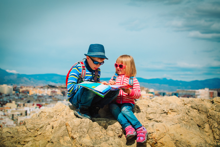 little boy and girl travel in city looking at mapの写真素材