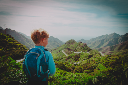 little boy hiking travel in mountains looking at viewの写真素材