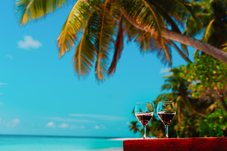 two wine glasses on tropical sand beach vacationの写真素材