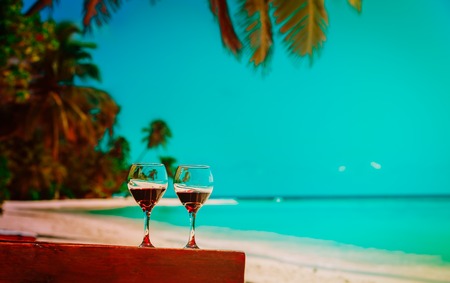 two wine glasses on tropical sand beach vacationの写真素材