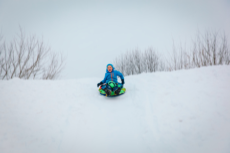 little boy enjoy winter slide, play in natureの写真素材