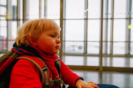 little baby girl with backpack travel in airport