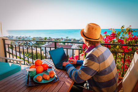 remote work concept- young man with laptop on scenic terraceの写真素材