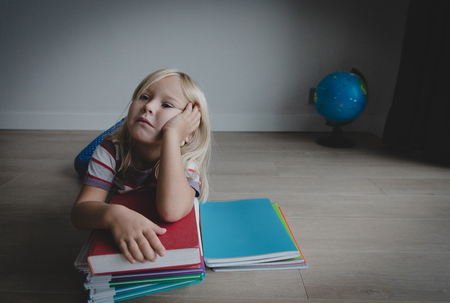 little girl tired stressed of doing homework, bored, exhaustedの写真素材