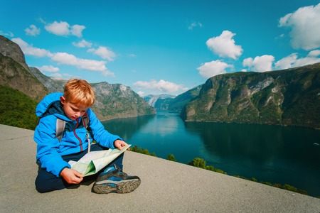little boy travel hiking in nature looking at mapの写真素材