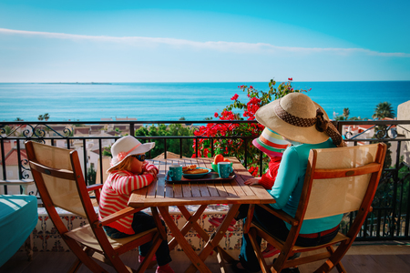 family having breakfast on balcony terrace with sea viewの写真素材