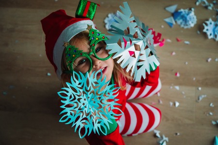 cute little girl cut snowflakes for Christmas celebrationの写真素材