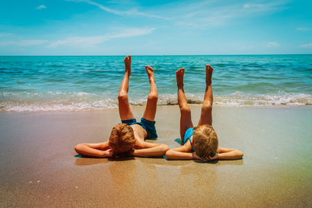 little boy and girl relax on tropical beachの写真素材