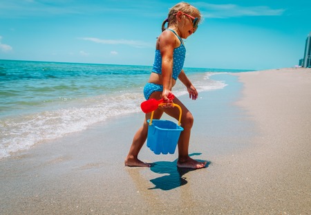 cute little girl play with sand on beachの写真素材