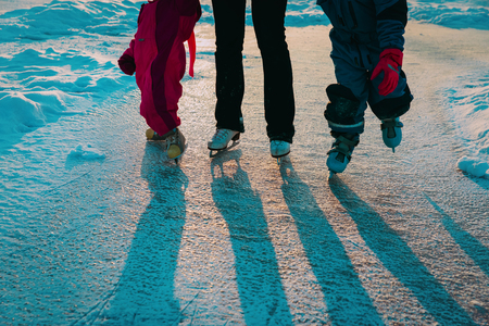mother and kids skating together in winterの写真素材