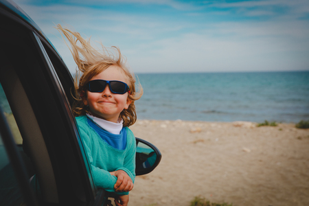 cute happy little girl enjoy travel by car at seaの写真素材