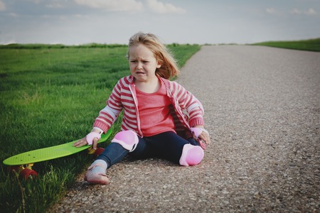 crying little girl fall off from skateboard, injury