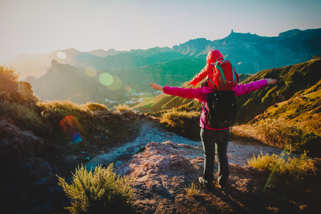 happy mom with little daughter enjoy travel in sunset mountainsの写真素材