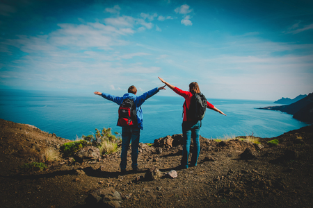 happy young couple hiking in mountains at seaの写真素材