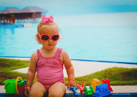 cute little girl play with toys on tropical beachの写真素材
