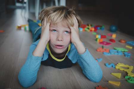 sad child, stress, exhaustion with toys scattered aroundの写真素材