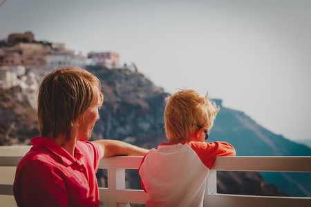 father and little son looking at caldera in Santorini, Greeceの写真素材