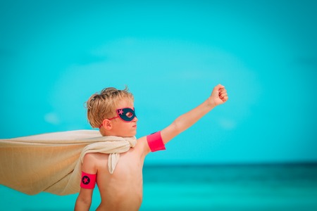 happy cute little boy play superhero on tropical beachの写真素材