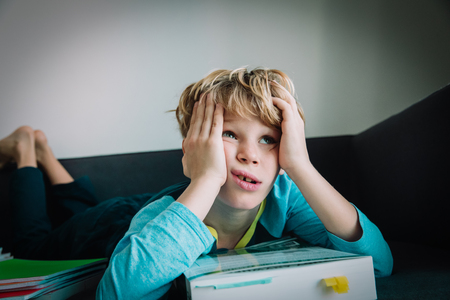 little boy tired of reading, kid bored of doing homeworkの写真素材